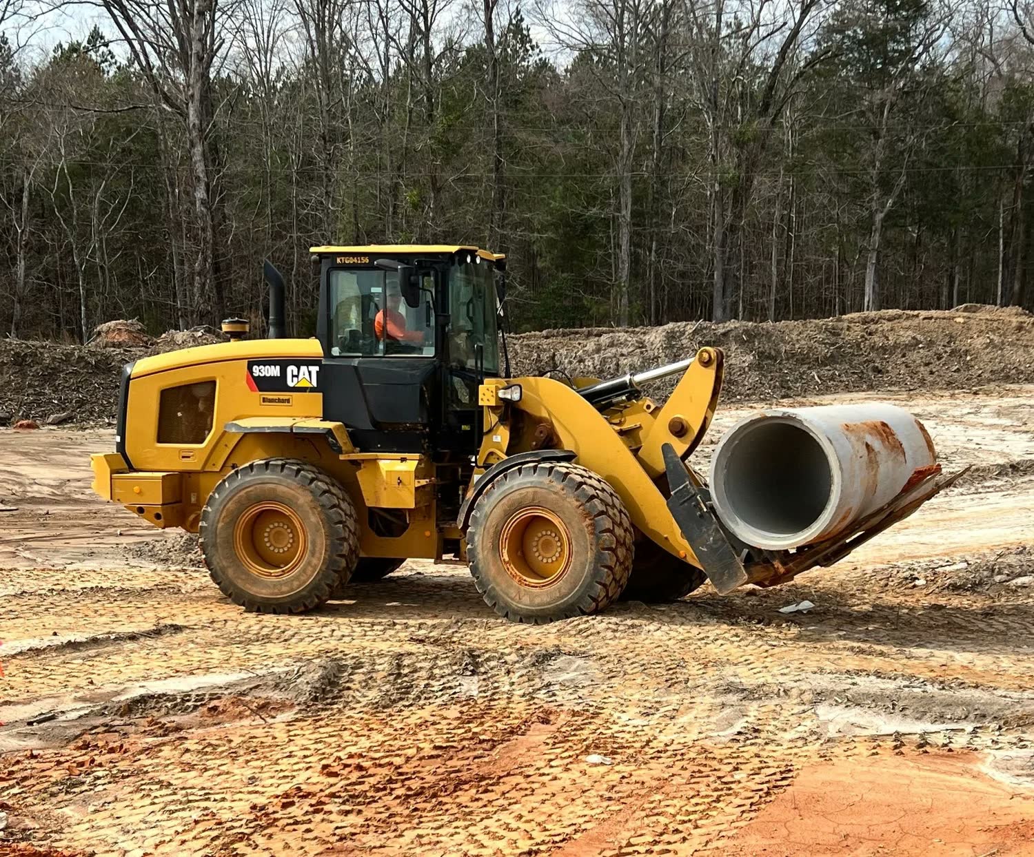 Wheel loader and a string of dump trucks on a graded haul road.