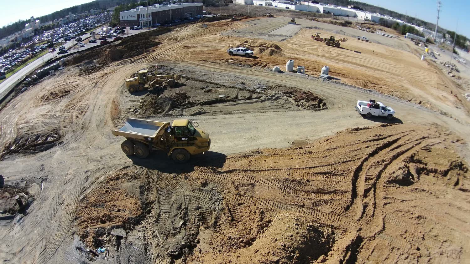 Excavator loading a dump truck in a deep earth cut under a blue sky.
